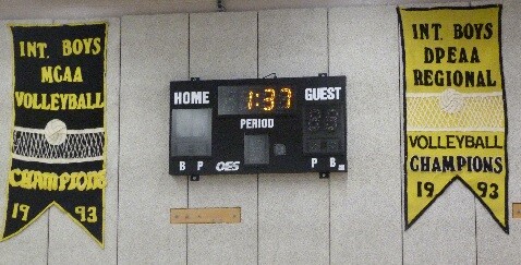 Banners and a scoreboard on a gym wall